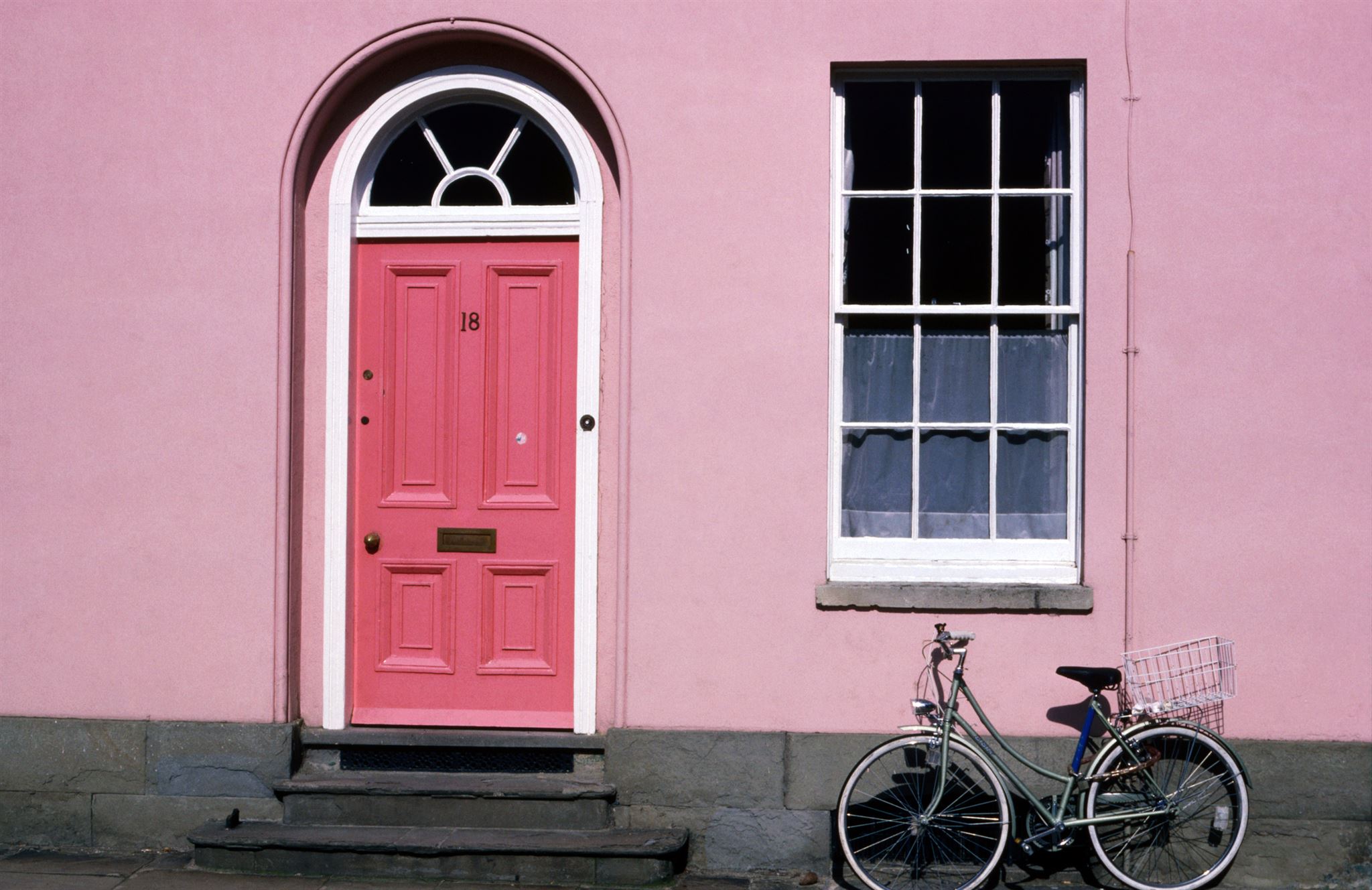 Pink-house-with-pink-entrance-with-window-and-bike